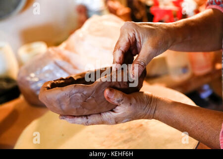 Hands of mixed race woman shaping clay in art studio Stock Photo