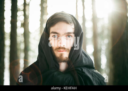 Caucasian man with beard wearing robe in forest Stock Photo