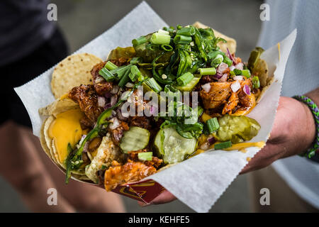 Hand holding loaded nachos Stock Photo