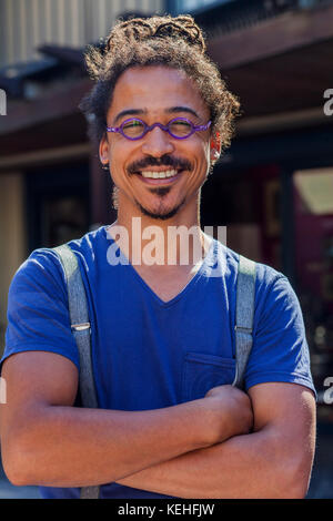 Smiling mixed race man wearing suspenders Stock Photo