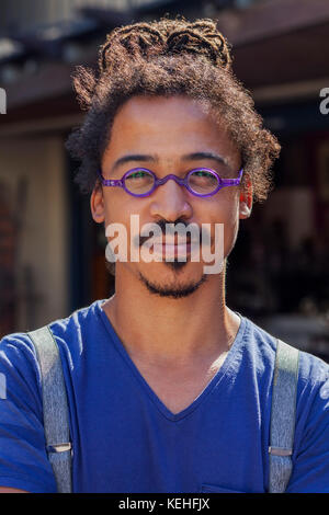 Serious mixed race man wearing suspenders Stock Photo