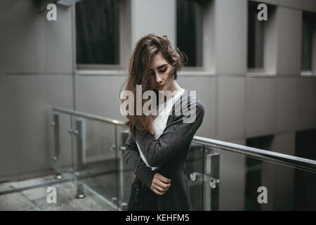 Pensive Caucasian woman standing near railing Stock Photo