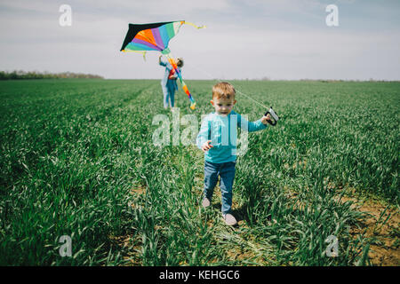 Caucasian boy and grandmother flying kite in field Stock Photo