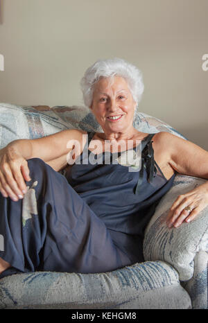 Portrait of smiling Caucasian woman sitting on sofa Stock Photo