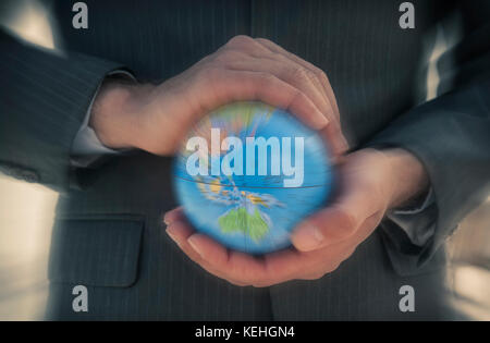 Caucasian businessman holding defocused globe in hands Stock Photo