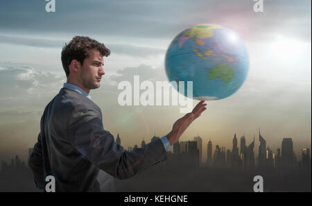 Caucasian businessman spinning globe on finger near city skyline Stock Photo