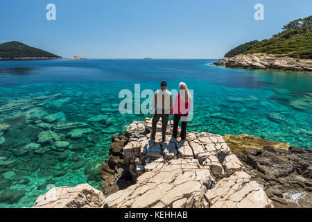Caucasian couple standing on rock admiring lake Stock Photo