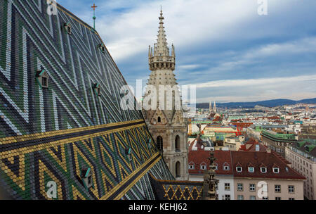 Aerial view over the rooftops of Vienna from the north tower of St. Stephen's Cathedral including the cathedral's famous ornately patterned, multi col Stock Photo