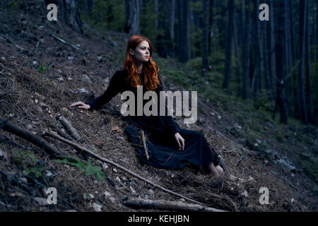 Caucasian woman sitting on hill Stock Photo