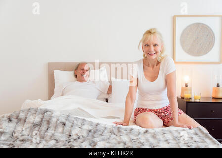 Colour portrait of nude couple in bed holding each other Stock Photo