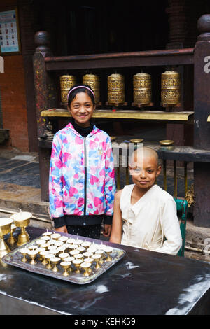 Young Buddhist monk and assistant, Golden Temple or Hiranya Varna Mahavihar, Kathmandu, Nepal. Stock Photo