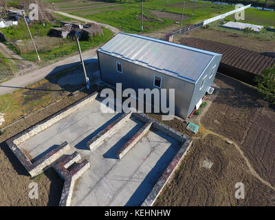 Buildings on the site. Hangar from metal profile, corrugated. The foundation of the house Stock Photo