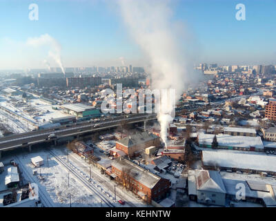 Winter town. Frosty sunny day in the city. Snow on the streets and smoke from the boiler rises. Frost and sun, a wonderful day. Stock Photo