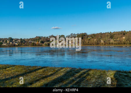 Inchgarth Reservoir and houses in Cults, Aberdeen, Scotland, 18 January 2017. Reservoir water frozen on a chilly winter morning. Stock Photo