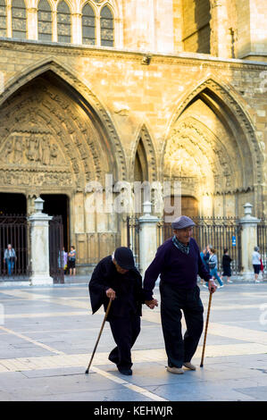 Elderly couple with walking sticks leave after Catholic Mass at Santa María de León Cathedral in Leon, Castilla y Leon, Spain Stock Photo