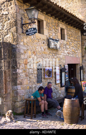 Locals at a traditional bar in cobbled street of Calle Del Canton in Santillana del Mar, Northern Spain Stock Photo