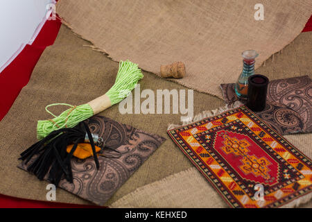 Sewing textile or cloth. Gold scissors pin cushion, and natural white fabric. Work table of a tailor. Shallow depth of field, Focus on scissors. Stock Photo