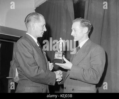 English footballer Tom Finney being presented with the trophy for Footballer Of The Year 1957, by Stanley Matthews.Sir Thomas Finney, CBE (5 April 1922 – 14 February 2014) was an English footballer, famous for his loyalty to his League club, Preston North End, for whom he made 569 first-class appearances, and for his performances in the England national side.   For his charitable work, he was appointed an Officer of the Order of the British Empire (OBE) in the 1961 New Year Honours and a Commander of the Order of the British Empire (CBE) in 1992, and Knighted in 1998. Stock Photo