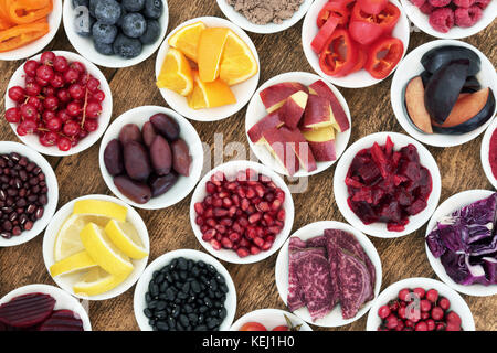 Healthy diet detox super food concept with fruit, vegetables and pulses high in anthocyaninsm, antioxidants and vitamins on rustic wood background. Stock Photo