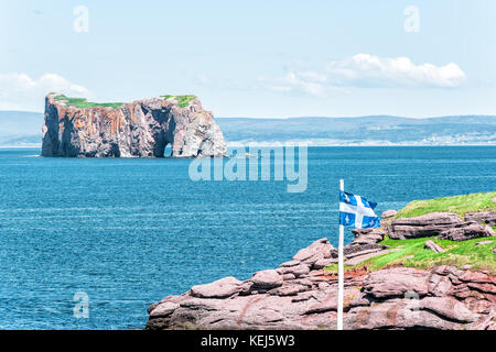 Bonaventure Island Park in Gaspe Peninsula, Quebec, Gaspesie region with picnic tables and view of Perce rock in summer by blue flag Stock Photo