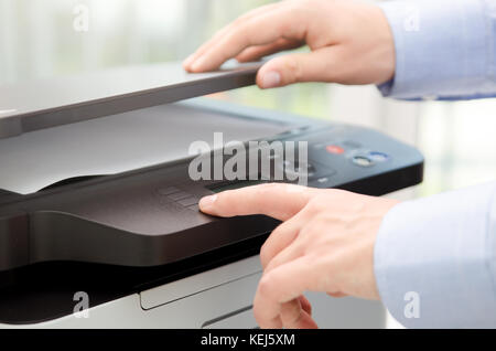 Hand press button on panel of printer. printer scanner laser office copy machine supplies start concept Stock Photo