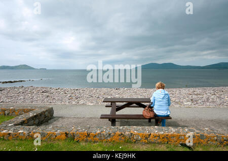 Woman relaxing on the seafront in Waterville, County Kerry, Ireland Stock Photo
