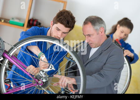 two mechanics in a bike repair station Stock Photo