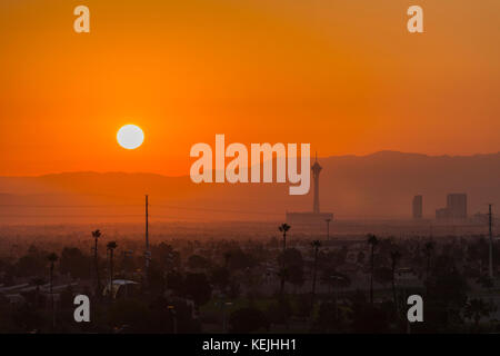 Las Vegas, Nevada, USA - October 13, 2017:  Hot Mojave desert sun rising behind the Stratosphere tower on the Las Vegas strip. Stock Photo