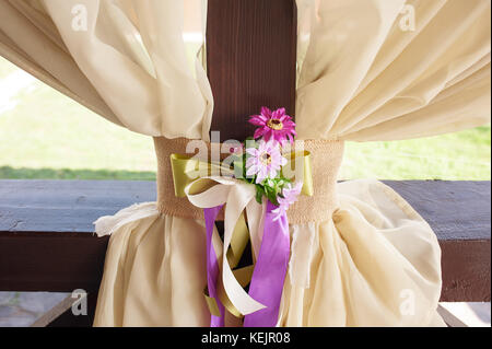 Beautifully decorated table for the wedding ceremony. Served banquet table decorated with fresh flowers in the open air. Stock Photo