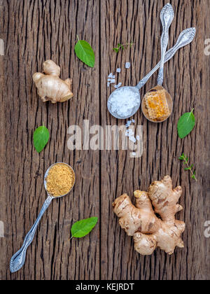 The ingredients of ginger tea with ginger roots , ginger powder , honey and peppermint on rustic wooden table. Stock Photo