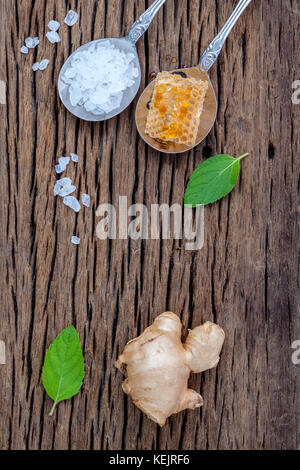 The ingredients of ginger tea with ginger roots , ginger powder , honey and peppermint on rustic wooden table. Stock Photo