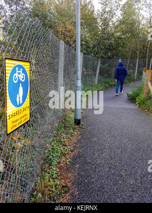 A woman walks down a shared path for cyclists and pedestrians in England, UK Stock Photo