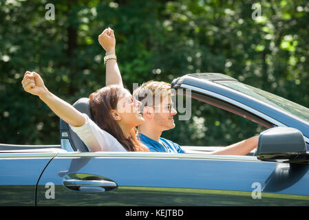 Happy Young Couple Enjoying Drive In A Car Stock Photo