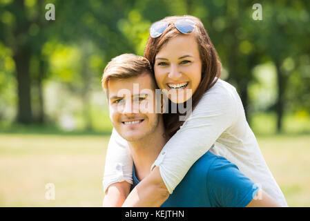 Portrait Of Happy Woman Hugging Her Husband From Behind Stock Photo
