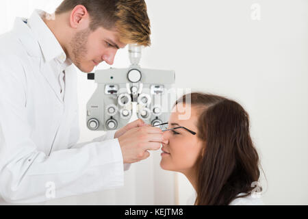 Young Male Handsome Optician Wearing Eyeglasses To The Woman Stock Photo