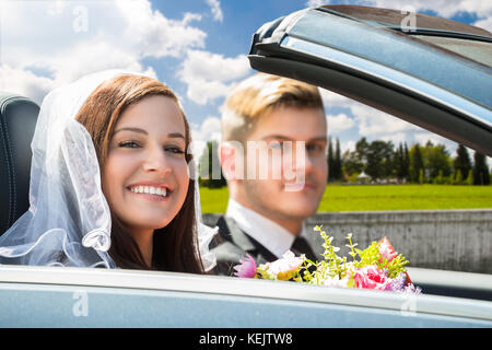 Portrait Of Young Just Married Couple In The Car Stock Photo