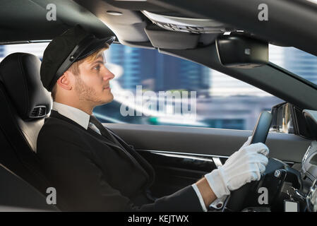 Portrait Of A Handsome Male Chauffeur Driving A Car Stock Photo