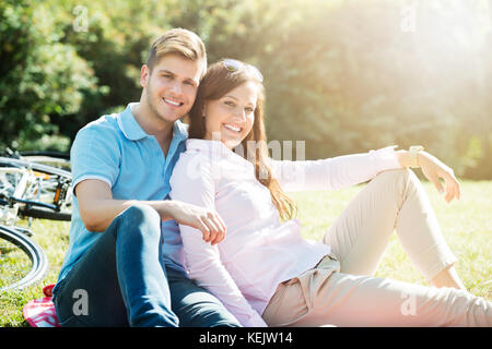 Portrait Of A Happy Young Couple In Park Stock Photo