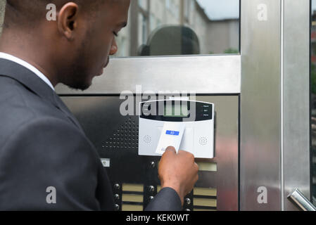 Close-up Of Young African Businessman Using Keycard To Open Door Stock Photo