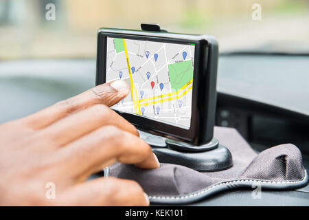 Close-up Of Person's Hand Using GPS Service While Driving Car Stock Photo