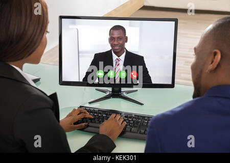Two Businesspeople Having Videoconference On Computer At Office Stock Photo