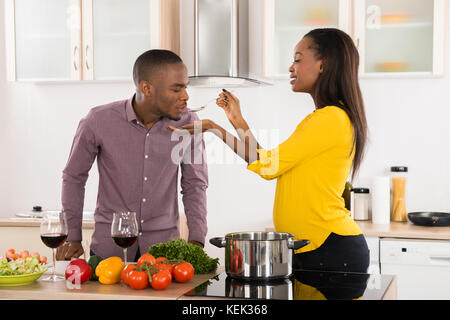 Photo Of Young Man Testing Food In Kitchen Stock Photo