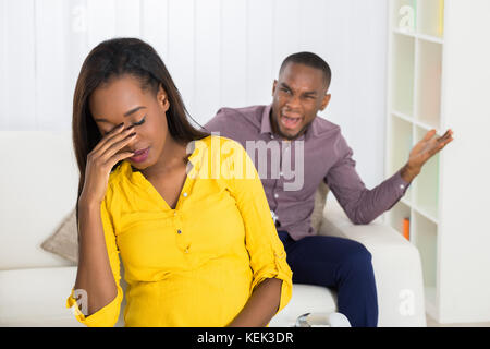 Unhappy Young Man Having Argument With Woman At Home Stock Photo
