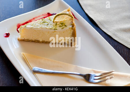 Close-up view of a dessert with a fork on a plate lying on a wooden table Stock Photo