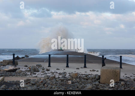 Aberystwyth, Ceredigion, Wales, UK 22nd October 2017. UK Weather: The tail end of Storm Brian continues along the west coast this morning as high tide approaches, bringing more waves crashing against Aberystwyth seafront, with the forecast predicting the wind to ease as the day moves on. (A block of concrete in the foreground that has shifted 15ft from yesterday’s stormy sea’s). © Ian Jones/Alamy Live News. Stock Photo