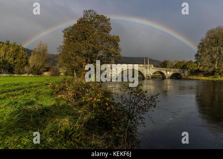 Aberfeldy, Scotland, UK. 22nd October, 2017. A rainbow arches over the top of the Tay Bridge in Aberfeldy. Opened in 1735 by General Wade and designed by William Adam, the bridge still carries road traffic from the Highlands int Aberfeldy. Credit: Rich Dyson/Alamy Live News Stock Photo