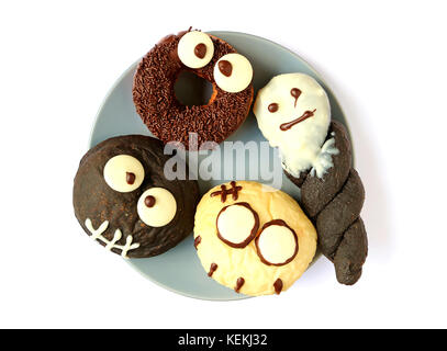 Halloween Ghosts and Monsters Shaped Doughnuts Served on the Plate Stock Photo
