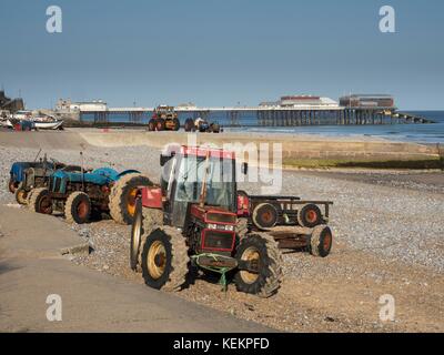Fishermens tractors on the beach at sunny Cromer, Norfolk, England Stock Photo