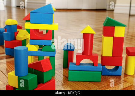 Colorful wooden building blocks on hardwood floor. Stock Photo
