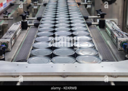 aluminum cans for food processed in factory line conveyor machine at canned food manufacturing, selective focus. Stock Photo